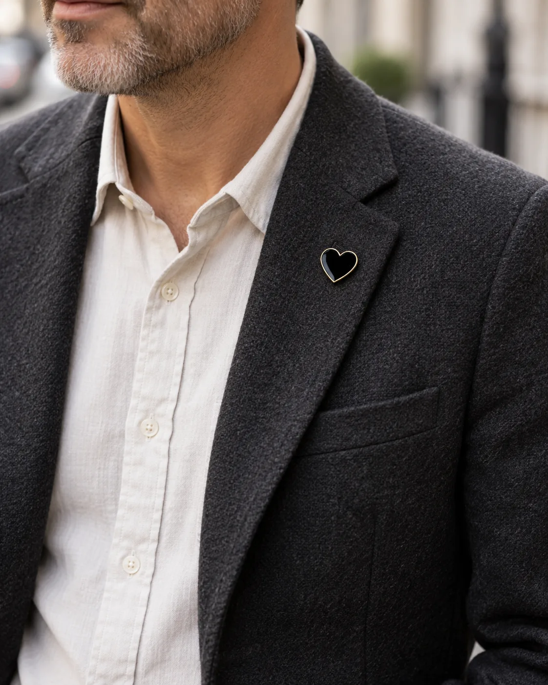 The Mourning Heart pin worn on the lapel of a dark jacket