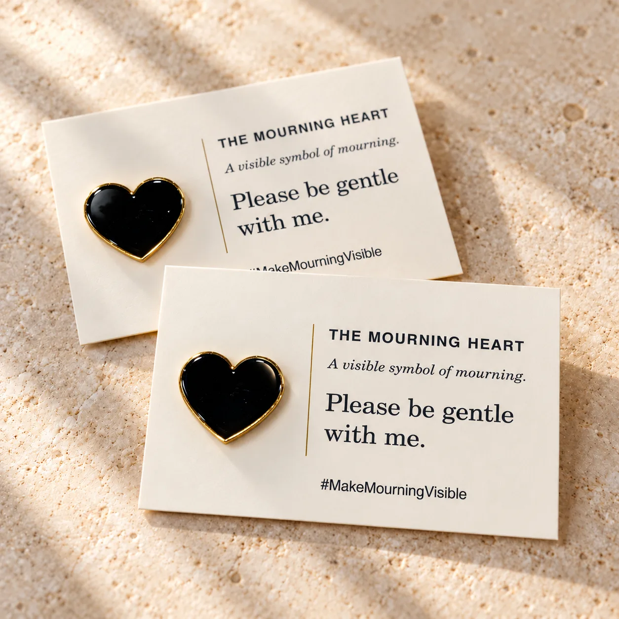 Two Mourning Heart pins displayed with their explanation cards
